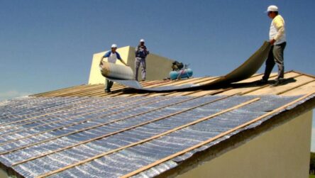 Trabajadores colocando aislantes termicos sobre una cubierta para optimizar el aislamiento y el confort interior de la construccion