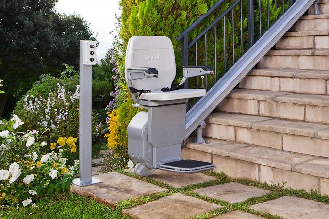 Silla salvaescaleras instalada en escalera exterior, una solucion practica y segura para personas mayores ofrecida por Ascensores Rosario.